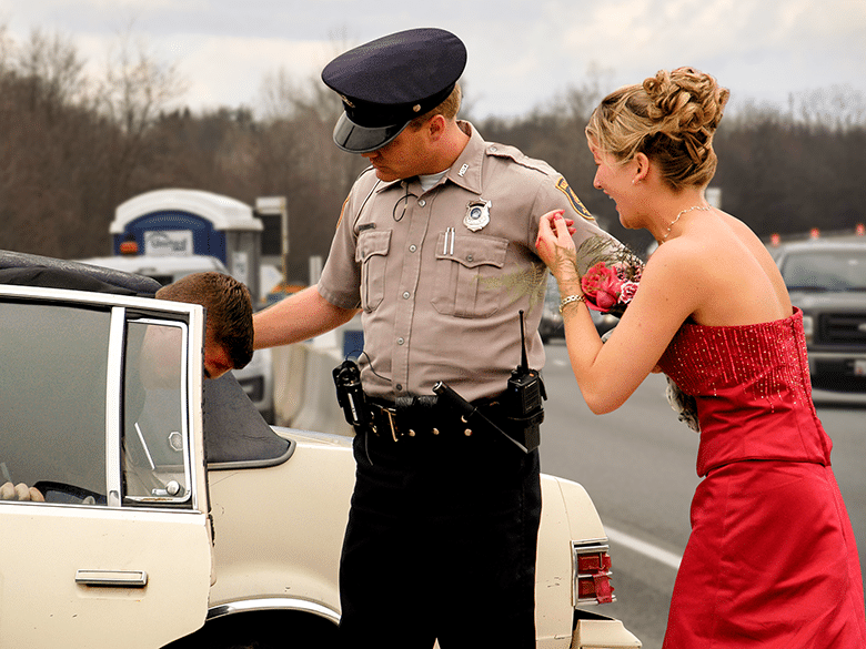 Police officer helping teenagers after a car accident