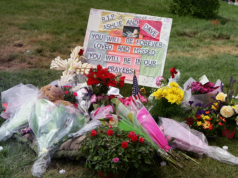 Flowers and sign at grave for teenagers lost in car accident